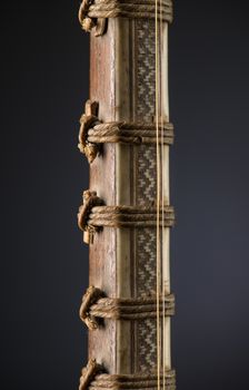 ancient Asian stringed musical instrument on black background with backlight. tuning peg