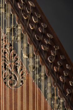 ancient Asian stringed musical instrument on black background with backlight. the similarity of the harp and psaltery. close-up