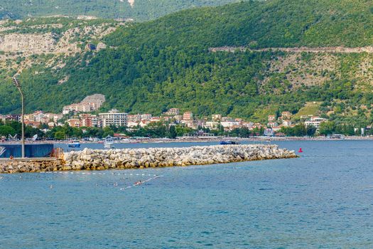 Stone pier and part of the beach in the bay of Budva in Montenegro