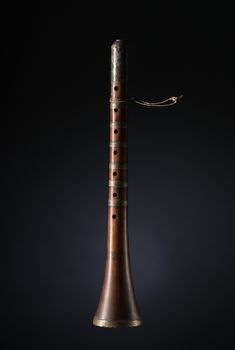 ancient asian woodwind musical instrument on a black background, surnay