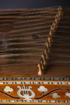 ancient Asian stringed musical instrument on black background with backlight. the similarity of the harp and psaltery. close-up