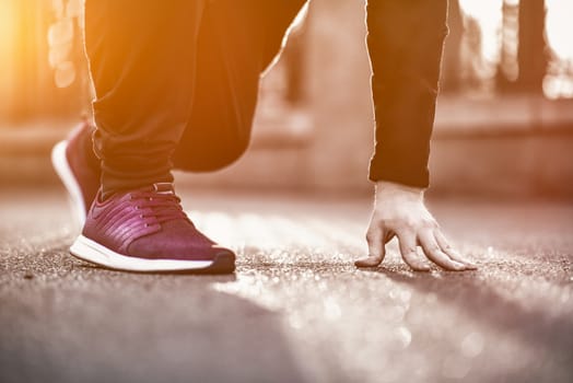 Hands of sportsman with pedometer tying shoelaces on sporty sneaker. Running equipment concept. Shoelaces tying by male hands.