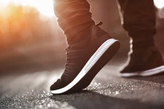 Man in sneakers walks down the street on a sunny day