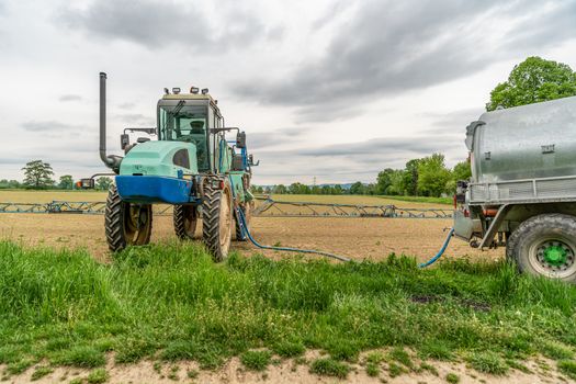 spraying weeds in a field by a tractor with a sprayer.