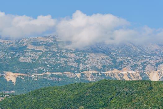 peaks and slopes of mountains covered with vegetation against a blue sky