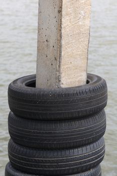 Many old used car tires overlap in plaster posts, for cushioning.