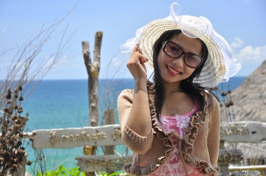 Portrait of young women wearing hats on a beautiful sunny summer day, With the sea blurred background.