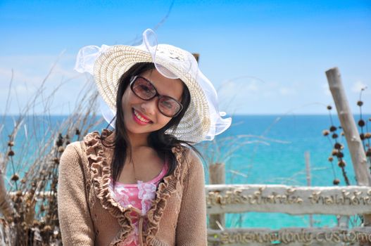 Portrait of young women wearing hats on a beautiful sunny summer day with the sea blurred background.