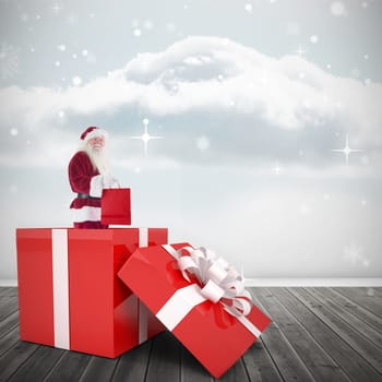 Santa standing in large gift against clouds in a room