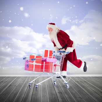 Santa pushing a shopping cart against clouds in a room