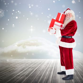 Santa carrying gifts against clouds on the horizon
