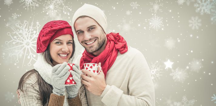 Winter couple holding mugs against snowflake pattern