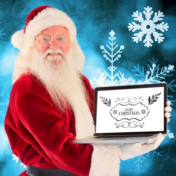Santa Claus presents a laptop against blue snow flake background