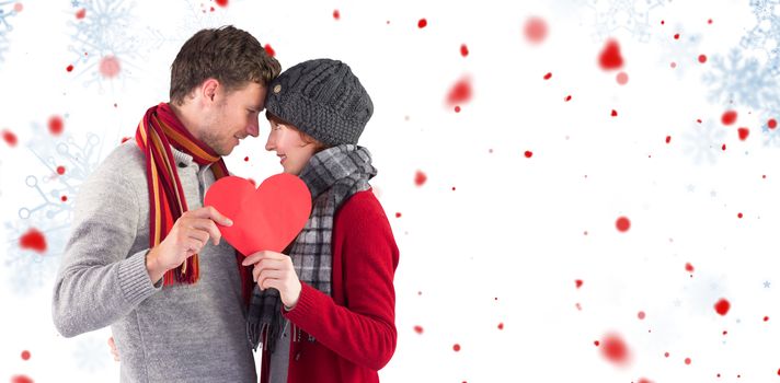 Couple holding a red heart against snowflake pattern
