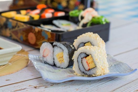 Tamagoyaki maki with white sesame seeds on square plate. Delicious japaneses food.