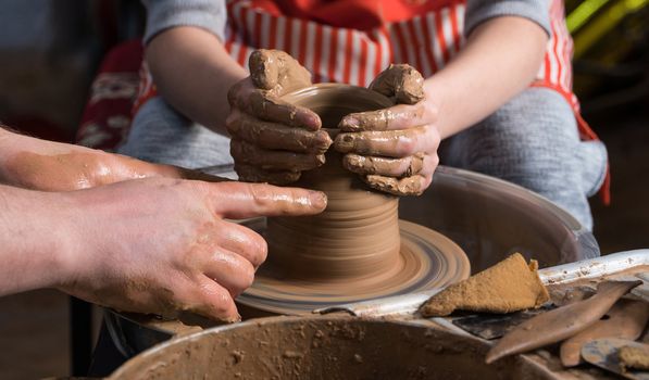 Teaching pottery to children. The teacher gives a master class in modeling