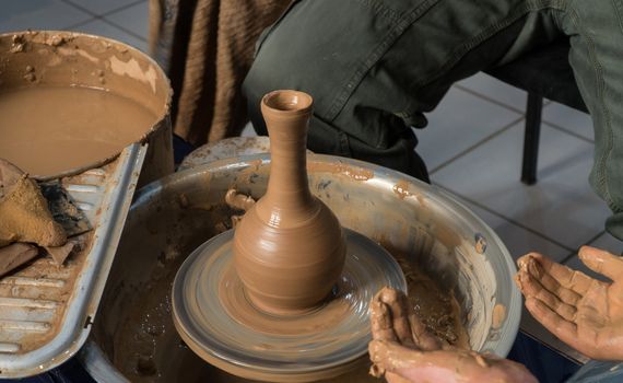 Teaching pottery to children. The teacher gives a master class in modeling