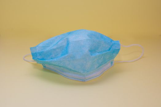 Surgical mask isolated against yellow background