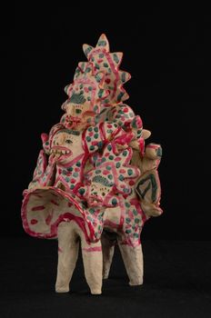 Asian and Oriental painted toy from burnt clay in the form of fantastic creatures and animals on a black background