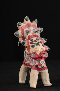 Asian and Oriental painted toy from burnt clay in the form of fantastic creatures and animals on a black background