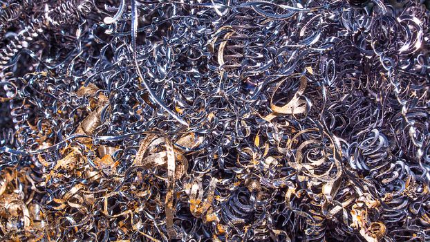 Metal background. Colored shavings. Wallpaper or screensaver of colored metallic chips.Abstract color background of metal shavings. Processing of ferrous and non-ferrous metals in a factory or plant