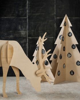 New Year's and Christmas decorations and fir plywood deer and a tree on a dark background