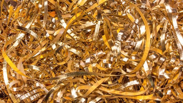 Abstract color background of metal shavings. Processing of ferrous and non-ferrous metals in a factory or plant. Metal background. Colored shavings. Wallpaper or screensaver of colored metallic chips