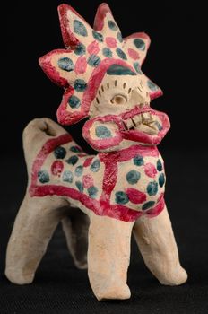 Asian and Oriental painted toy from burnt clay in the form of fantastic creatures and animals on a black background