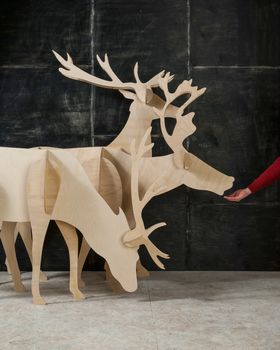 New Year's and Christmas decoration deer made of plywood and wood on a dark background