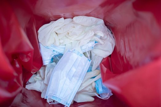 Inside view of waste bin with discarded gloves and mask