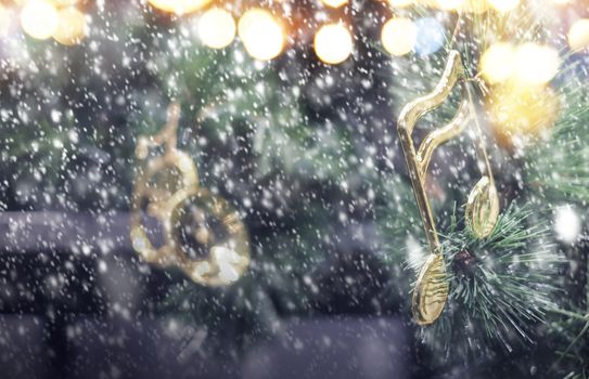 Music note decoration on christmas tree with snow falling in the winter