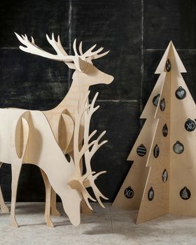 New Year's and Christmas decorations and fir plywood deer and a tree on a dark background