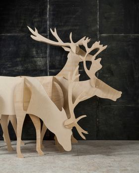 New Year's and Christmas decoration deer made of plywood and wood on a dark background