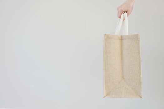 Woman hand holding sackcloth bag with copy space No plastic bag concept