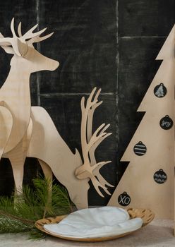 New Year's and Christmas decorations and fir plywood deer and a tree on a dark background