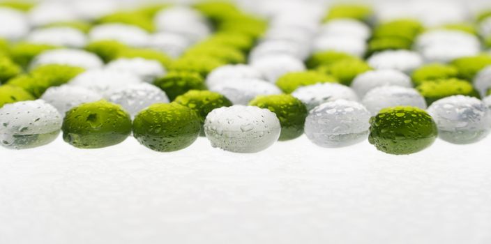 artificial round stones with water drop of green and white color. imitation pebbles
