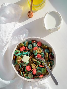 Trendy food - pancake cereal. Heap of colorful mini cereal pancakes. Tiny pancakes with natural color - green matcha, turquose spirulina, blue pea, red fragon fruit