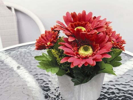 Artificial flowers in vase on the table