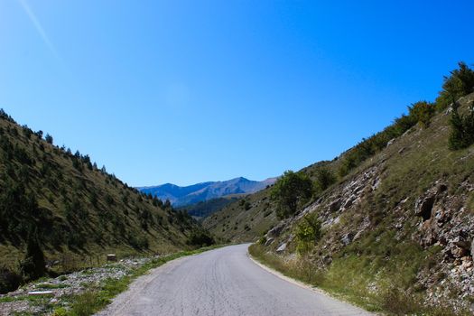 The road to the mountains. Mountains in the background. Between two hills. The road to the mountain Bjelasnica in Bosnia and Herzegovina.