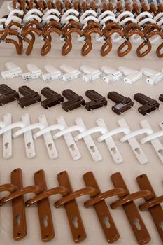 a set of white and brown metal handles and accessories for plastic windows and doors
