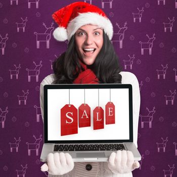 Smiling woman holding a laptop against purple reindeer pattern