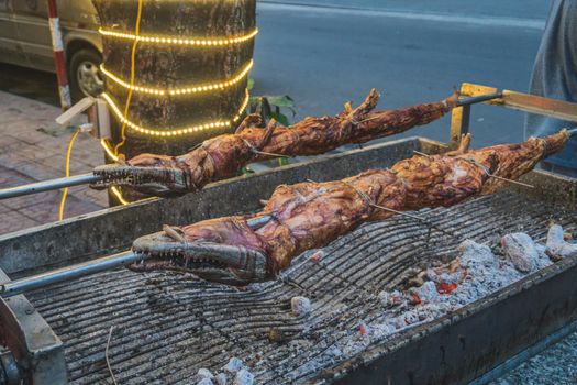 Grilled crocodile on the open fire at sea food restaurant, exotic meals in Viethnam, food of the asian cuisine, raw crocodile meat, exotic food.