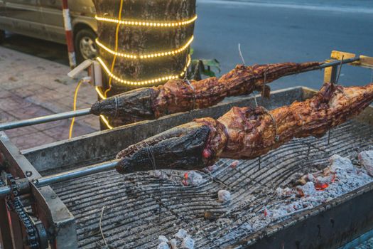 Grilled crocodile on the open fire at sea food restaurant, exotic meals in Viethnam, food of the asian cuisine, raw crocodile meat, exotic food.