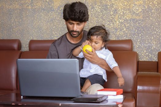 Young father with his little son working on laptop at home - Concept of work form home or wfh reality, People Lifestyles and technology.