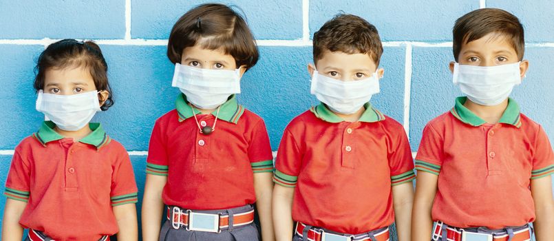 School preteen kids with protection face mask against new coronavirus, covid -19, nCov 2019 or sars cov 2 virus at school - children wore medical mask due to coronavirus outbreak