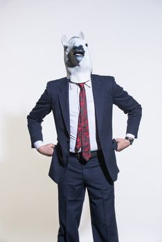 A man in a suit and a horse mask on a light background. Conceptual business background