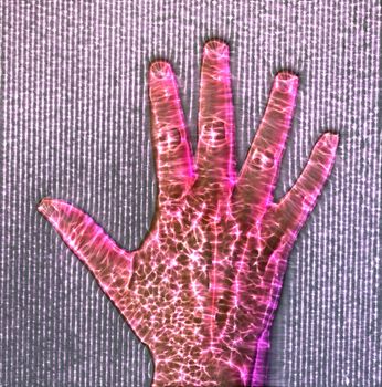 3D-Illustration of a glowing human female hand with a kirlian aura showing different symbols.