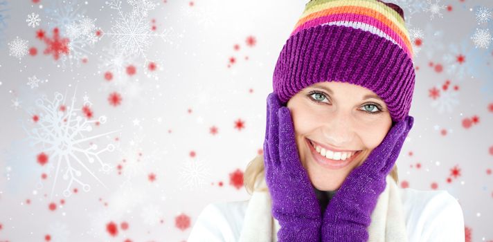 Radiant young woman with cap and gloves in the winter against snowflake pattern