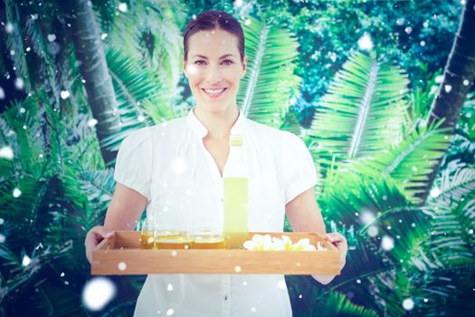 Snow against smiling beauty therapist holding tray of beauty treatments