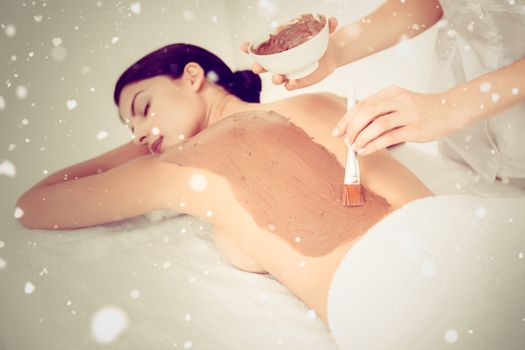 Snow against beautiful brunette enjoying a chocolate beauty treatment